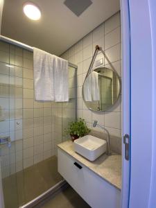 een badkamer met een wastafel en een spiegel bij Morcelli Mobiliados - Uniqo Smart Living in Santa Maria