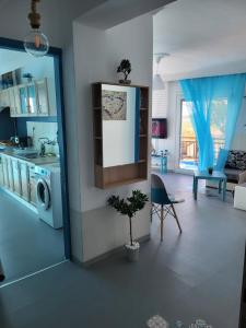 Upper Deck Apt. في ني بيراموس: مطبخ وغرفة معيشة مع حوض وغسالة ملابس