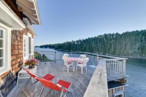 a deck with a table and chairs on the water at Oceanfront Cottage with Deck 2 Mi to Boothbay Harbor in West Boothbay Harbor