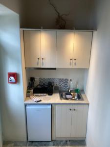 a small kitchen with a sink and white cabinets at Διώροφη κατοικία Γλώσσα Σκοπέλου in Skopelos Town