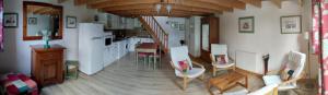 a kitchen and living room with a table and chairs at Buddleia in Cherbonnières