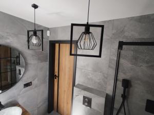 a bathroom with three lights hanging over a door at Stania Loft CENTRUM in Boszkowo-Letnisko