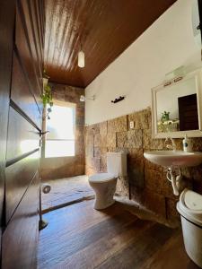 a bathroom with a toilet and a sink at Tropical Hostel in Pipa