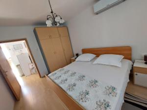 a small bedroom with a bed and a dresser at Apartman Draga in Podstrana