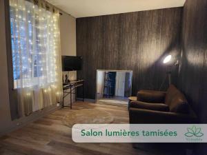 ein Wohnzimmer mit einem Sofa und einem Fenster mit Beleuchtung in der Unterkunft Logement cocooning Indépendant avec Salle de jeux in Chémery