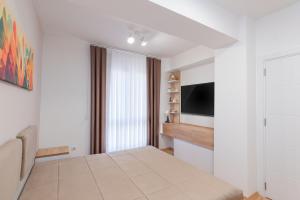 a white room with a table and a television at Aria Pearl Apartment in Bitola