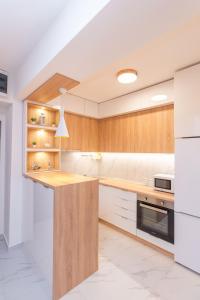 a kitchen with white counters and wooden cabinets at Aria Pearl Apartment in Bitola