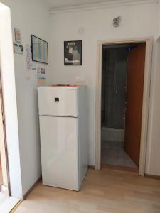 a white refrigerator in a room with a doorway at Apartman Draga in Podstrana