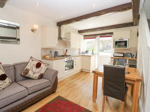 a kitchen and living room with a couch and a table at Katie's Cottage in Skipton