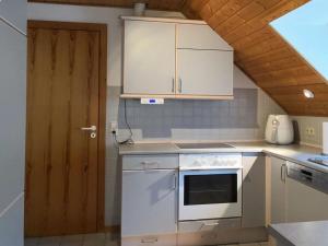 uma cozinha com electrodomésticos brancos e uma porta de madeira em Holiday apartment Schütt in Seedorf em Seedorf