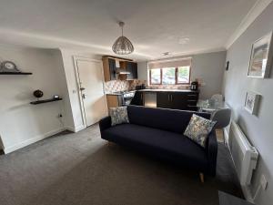 a living room with a couch and a kitchen at Whittlesey town centre apartment in Peterborough