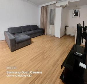 a living room with a couch and a television at Apartment on St. Nikoloz Baratashvili 1 in Batumi