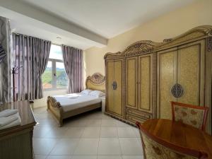 Gramsh的住宿－Hotel Latifi，一间卧室配有一张床和一个大型木制橱柜
