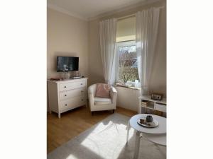 a living room with a chair and a window at Holiday apartment 2 in the Maaßen country house in Stakendorf