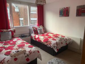 a bedroom with two beds and a window at Jeans Place Watergate St Rows near racecourse in Chester