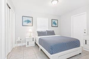 a white bedroom with a bed and a window at Annas Peaceful Retreat Luxury Suite in Fort Lauderdale