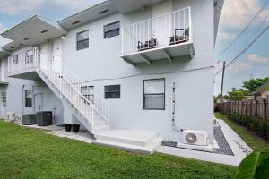 a white house with stairs and a balcony at Annas Peaceful Retreat Luxury Suite in Fort Lauderdale