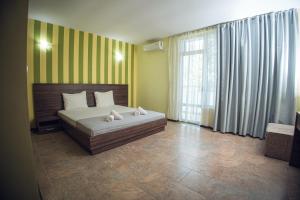 a bedroom with a bed and a large window at Хотел и Вили Марая apartament in Tsarevo