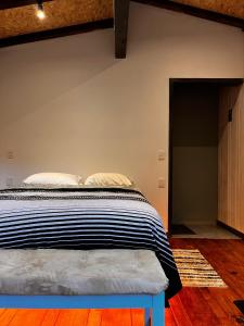 a bedroom with a bed with a blue bench next to it at Tiny Cozy Cabin las moras in San Mateo Río Hondo