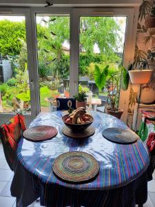 una mesa con platos y un bol de fruta en ella en La Villa Bleue, en Beauchastel