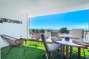 comedor con mesa y sillas en el balcón en Casa frente al mar con piscina privada, en Sagunto