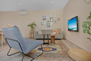 a living room with a chair and a television at Casa Pitaya in Alhaurín el Grande