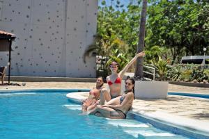 Tres mujeres sentadas en una piscina en Surf Ranch Hotel & Resort en San Juan del Sur