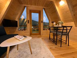 a living room with a table and chairs and windows at Dream House Una in Orašac