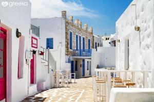 a street with white buildings and tables and chairs at Luxury Naxos Apartment Deluxe Triple Studio 150M From St George Beach City Center Saint George in Naxos Chora +20 photos