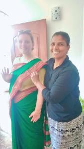 a woman is standing next to a woman holding a baby at Kuma Beach side Villa in Wadduwa