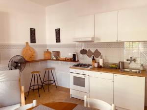 uma cozinha com armários brancos e um forno com placa de fogão em Domus Messapia em Ceglie Messapica