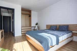 um quarto com uma cama grande e almofadas azuis em Oboźna 25 em Zamość