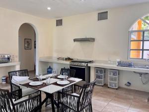 a dining room with a table and chairs in a kitchen at Orquideas Villas & Studios at Country House in Cancún