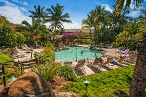 einen Pool in einem Resort mit Stühlen und Palmen in der Unterkunft Maui Kamaole I111 - MCH in Kihei