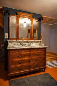 a bathroom sink with a mirror and a wooden dresser at Landhausromantik pur in Kirchheim