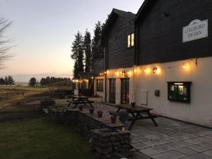 um grupo de mesas de piquenique fora de um edifício em Rooms & Camping Pods at Colliford Tavern em Bodmin