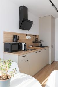 uma cozinha com armários brancos e um micro-ondas preto em Oboźna 25 em Zamość