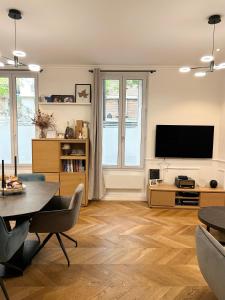 a living room with a table and a television at Paris 16 lux and cozy 2 bedroom in Paris