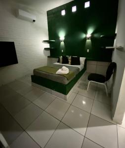 sypialnia z łóżkiem i krzesłem w pokoju w obiekcie Pousada La Luna w mieście Paracuru