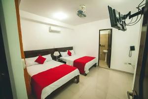 a hotel room with two beds and a mirror at Hotel Luxor Pucallpa in Pucallpa