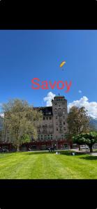 un gran edificio con una cometa en el cielo en SAVOY 26, en Interlaken