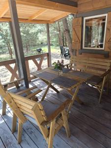 einen Picknicktisch und Stühle auf der Veranda einer Hütte in der Unterkunft Świetna Chatka in Świętne