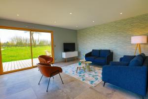 ein Wohnzimmer mit zwei blauen Sofas und einem TV in der Unterkunft chez watersy in Belle-et-Houllefort