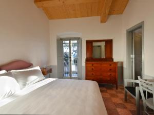 a bedroom with a bed and a dresser and a mirror at I Casali del Pino in La Giustiniana