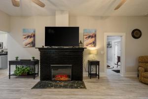 a living room with a fireplace with a flat screen tv at Historic home lake access, near parks and venues in Winter Haven +51 photos