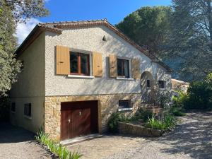 una casa de piedra con una puerta de garaje marrón y ventanas en la maison du colonel, en Aubres