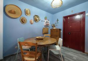 comedor con mesa y sillas y puerta roja en Casa Evita en Estepona