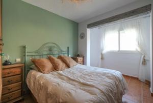 sypialnia z łóżkiem i oknem w obiekcie Casa Evita w mieście Estepona
