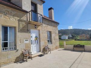 a stone building with two chairs outside of it at Ventana al Atlantico - House across from the beach in Porto do Son