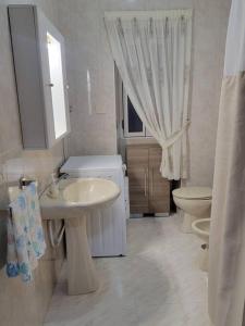a white bathroom with a sink and a toilet at Ventana al Atlantico - House across from the beach in Porto do Son +17 photos